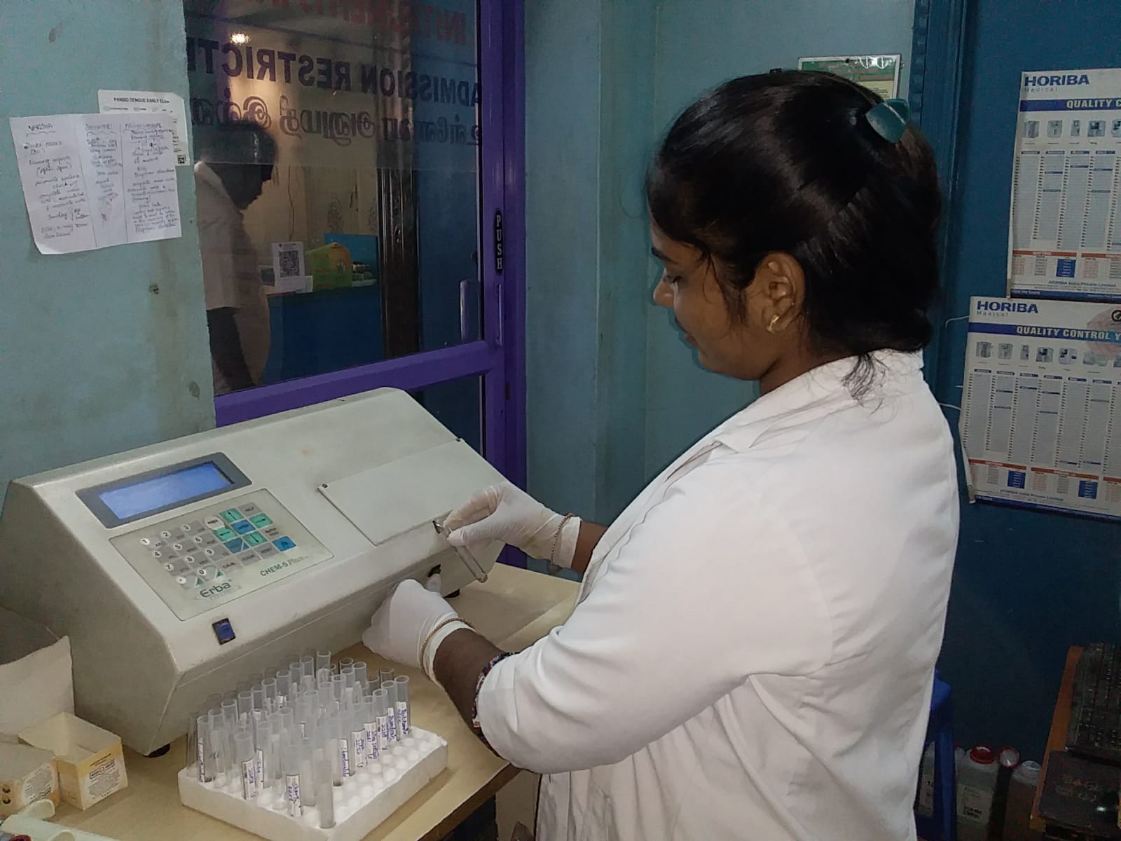Student loading sample tubes into a biochemistry analyzer